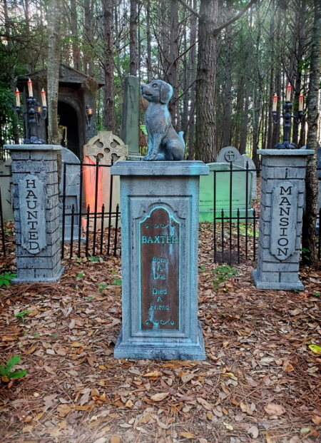 A serene cemetery with tall trees and decorated tombstones.
