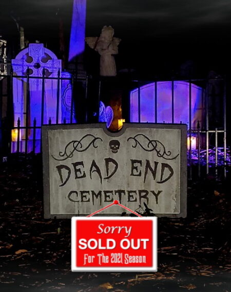 Dead End Cemetery sign lit by eerie purple lighting.