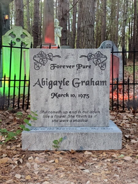 A gravestone for Abigayle Graham with a Forever Yours inscription in a fenced area.