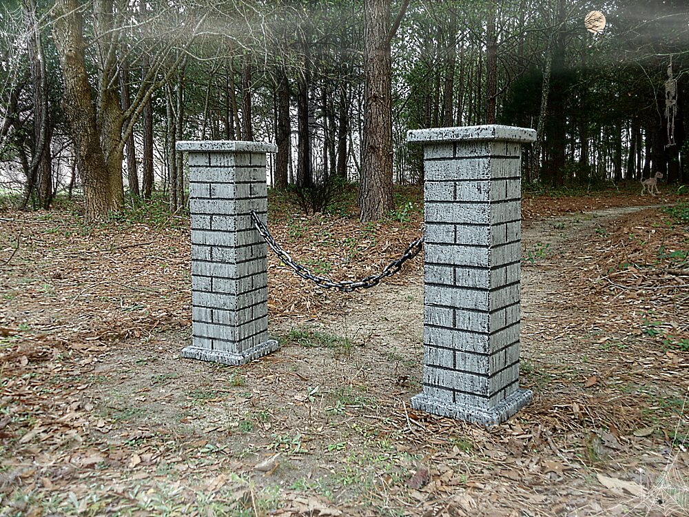 Two brick pillars connected by a rusty chain outdoors. Two brick pillars connected by a rusty chain outdoors.