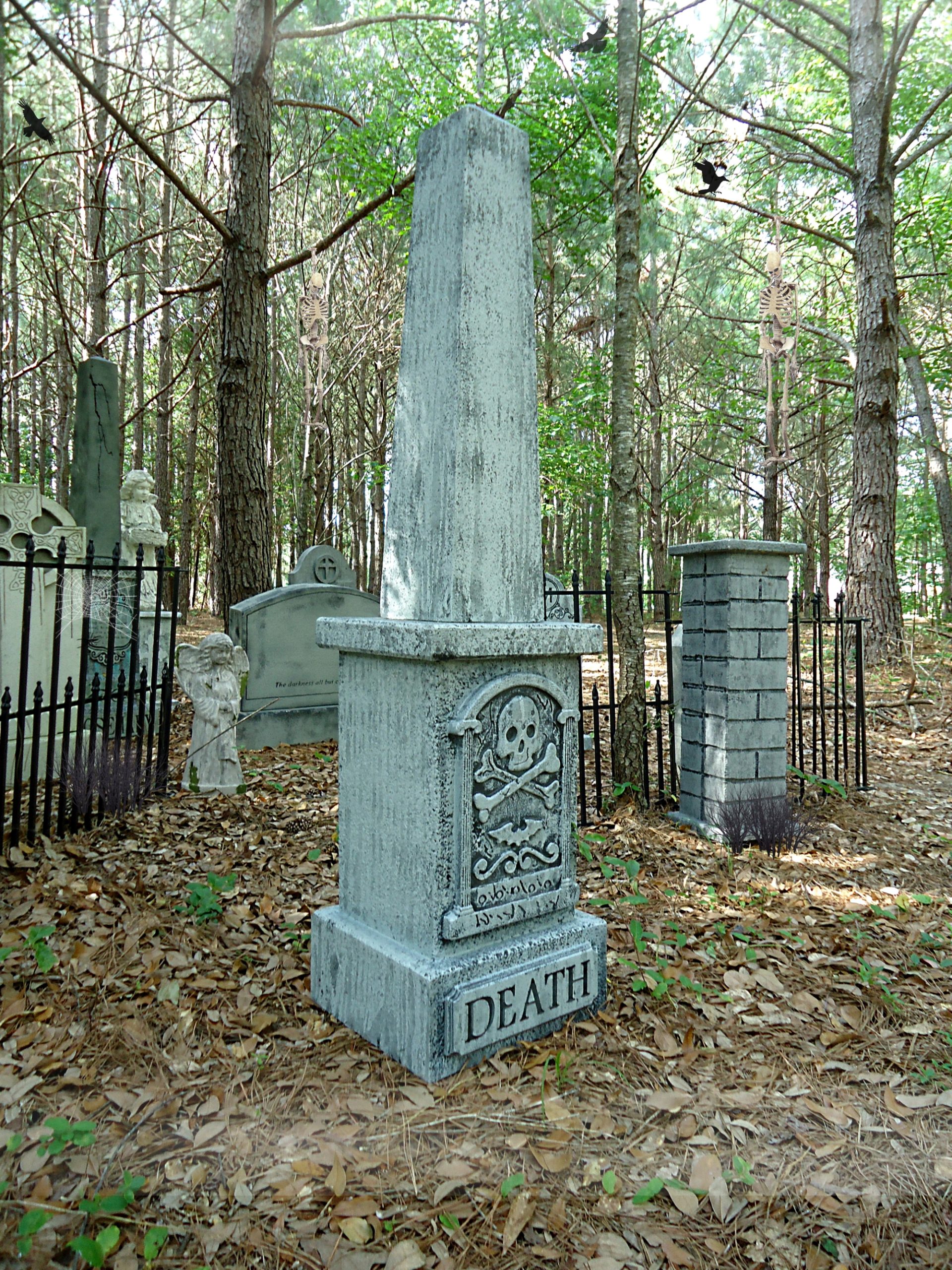A weathered gray obelisk tombstone in a forest cemetery. A weathered gray obelisk tombstone in a forest cemetery.