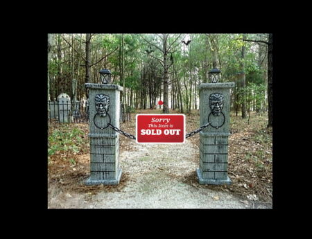 Gated private property entrance with warning signs in a wooded area.