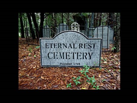 Stone sign marking Eternal Rest Cemetery surrounded by pine needles.