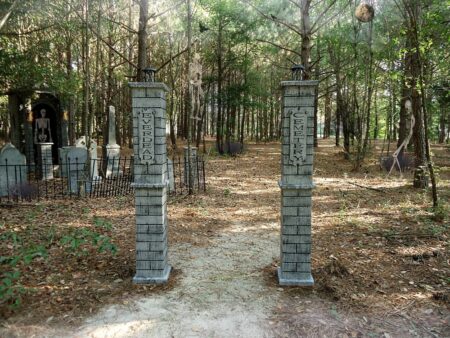 Stone pillars marking a wooded path in a forested area.