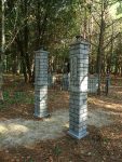 Stone pillars marking a wooded path in a forested area.