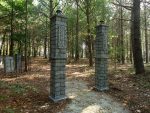 Stone pillars marking a wooded path in a forested area.