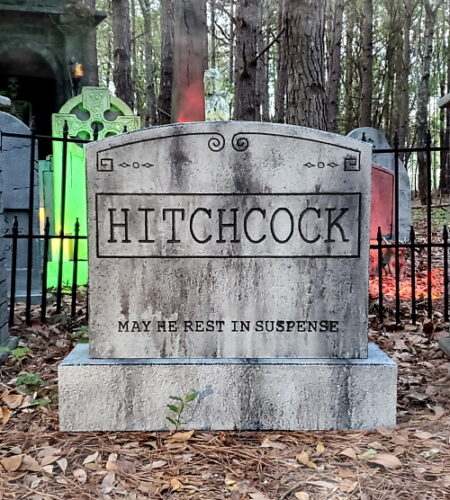 A weathered stone monument labeled 'Hitchcock' in a forested area.