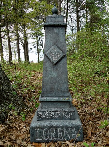 A weathered stone monument with the name 'Lorena' engraved at the base.