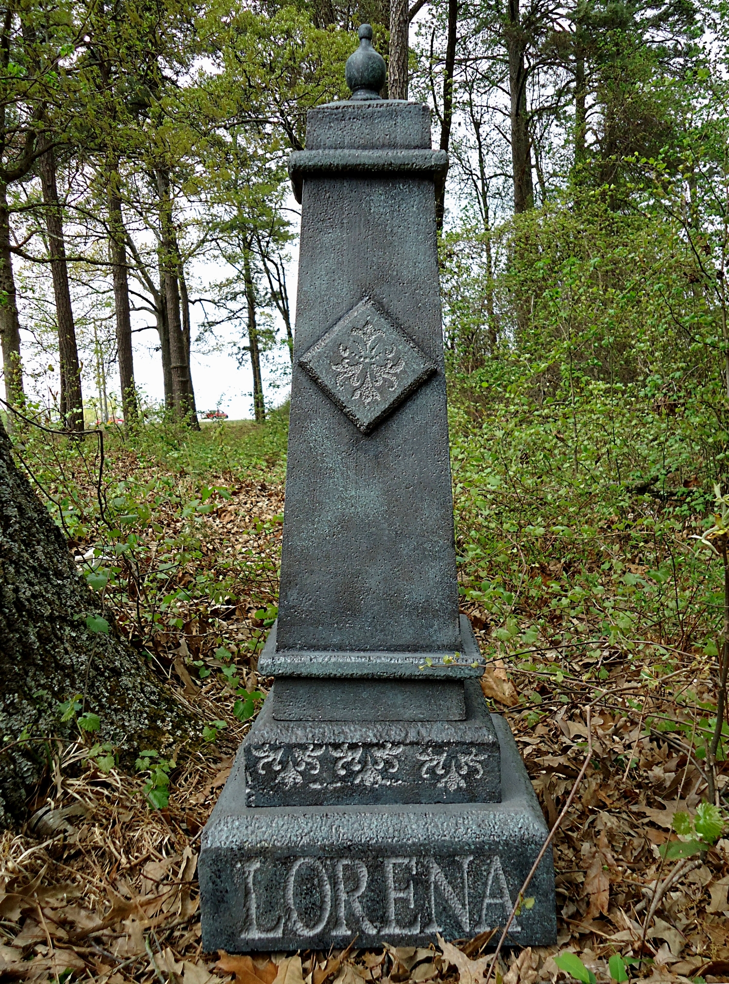 A weathered stone monument with the name 'Lorena' engraved at the base. A weathered stone monument with the name 'Lorena' engraved at the base.