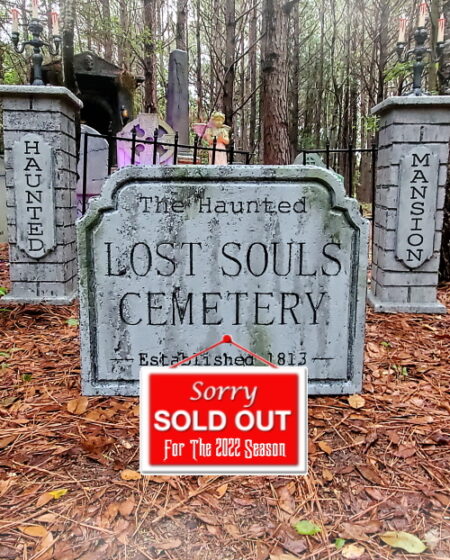 Entrance to a haunted-themed cemetery with a sold-out sign for a spooky event.