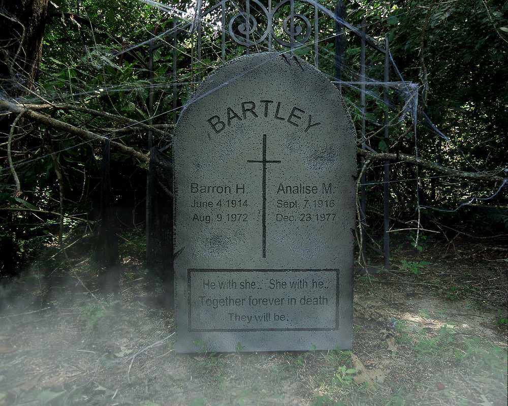 A weathered gravestone with inscriptions in a foggy, wooded area. A weathered gravestone with inscriptions in a foggy, wooded area.