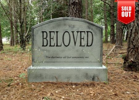 A gravestone engraved with 'BELOVED' in a forest setting.