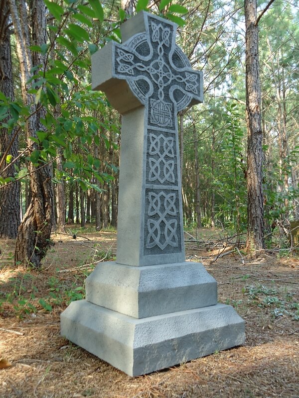 Stone Celtic cross monument in a wooded area. Stone Celtic cross monument in a wooded area.