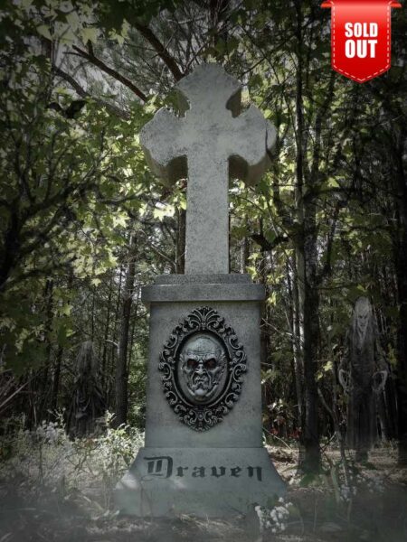 Eerie stone cross monument with a haunting face in the forest, marked as sold out.