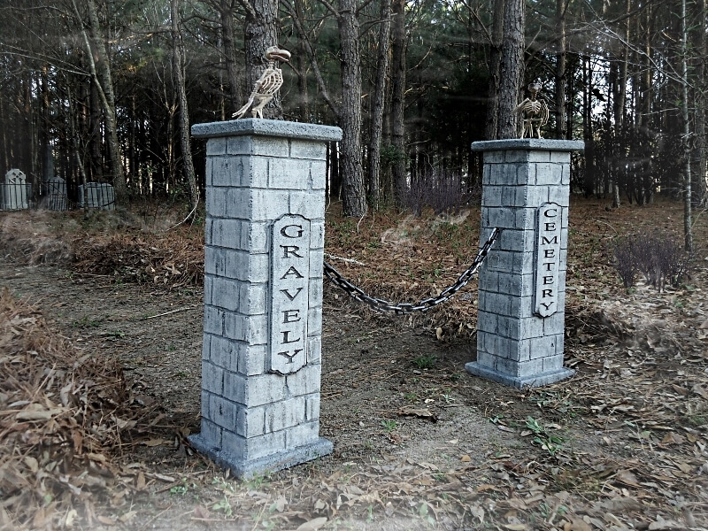 Two stone pillars with carved names in a wooded area. Two stone pillars with carved names in a wooded area.