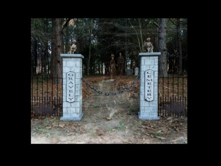 Two stone pillars at a forest entrance with a pathway beyond.