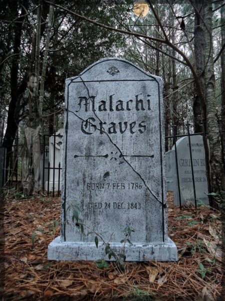 Old gravestone of Malachi Graves in a wooded cemetery.
