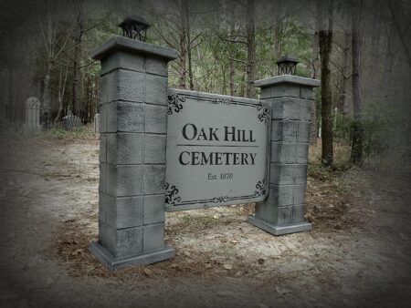 Entrance sign of Oak Hill Cemetery surrounded by trees.