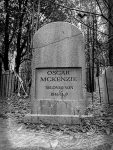 Gravestone of Oszune McKenzie in a wooded graveyard.