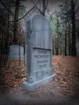 Gravestone of Oszune McKenzie in a wooded graveyard.